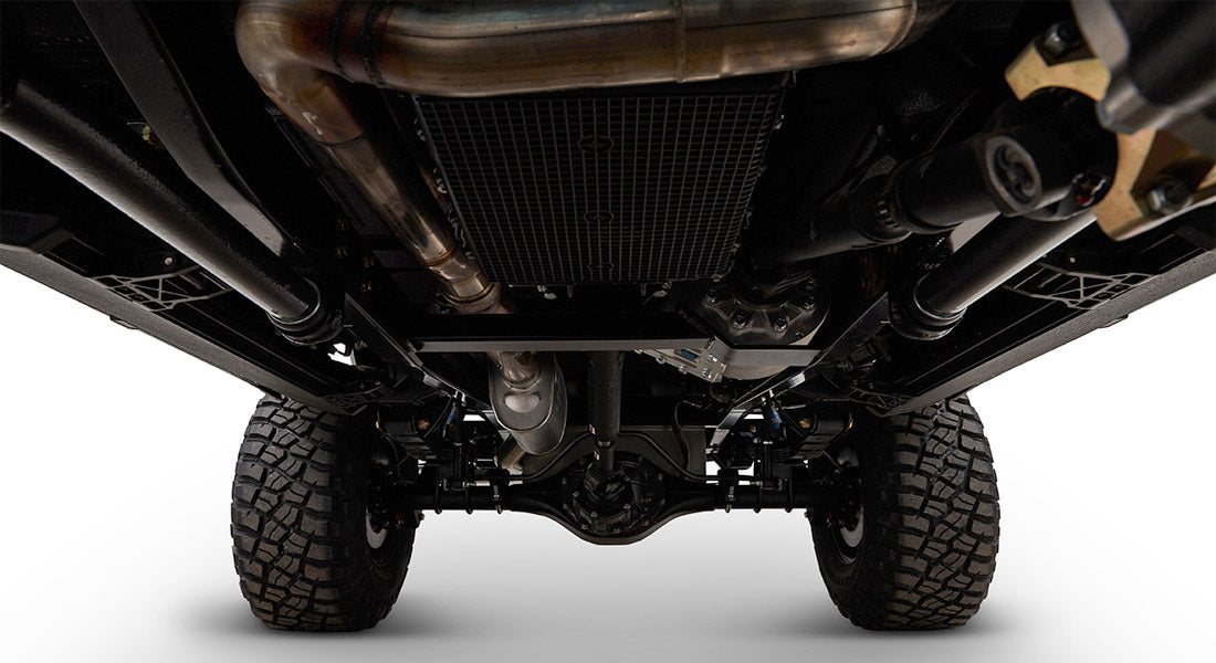 Underneath view of a vehicle showing suspension, exhaust, and tires