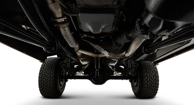Undercarriage of Classic Ford Bronco showing exhaust system and tires against white background