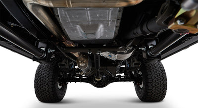 Undercarriage view showing suspension and exhaust components with rugged tires of a Classic Ford Bronco