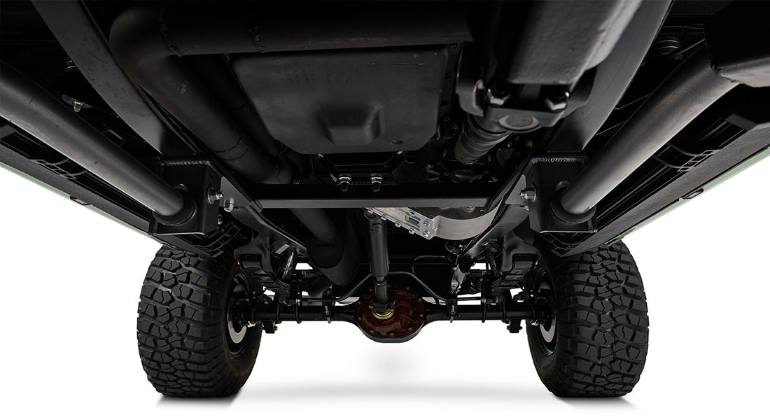 Undercarriage view showing suspension, axles, and exhaust of a Classic Ford Bronco with rugged tires