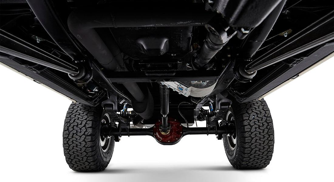 Undercarriage view of a Classic Ford Bronco showing rear axles, shocks, and tires.