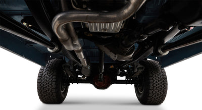 Undercarriage of Classic Ford Bronco showing exhaust pipes, differential, and tires from below