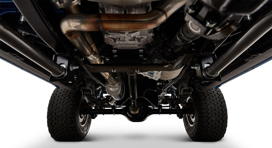 Undercarriage of Classic Ford Bronco showing exhaust system and rear axle with tires
