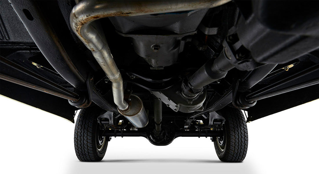Undercarriage view showing tires, exhaust pipe, and suspension components of a Classic Ford Bronco