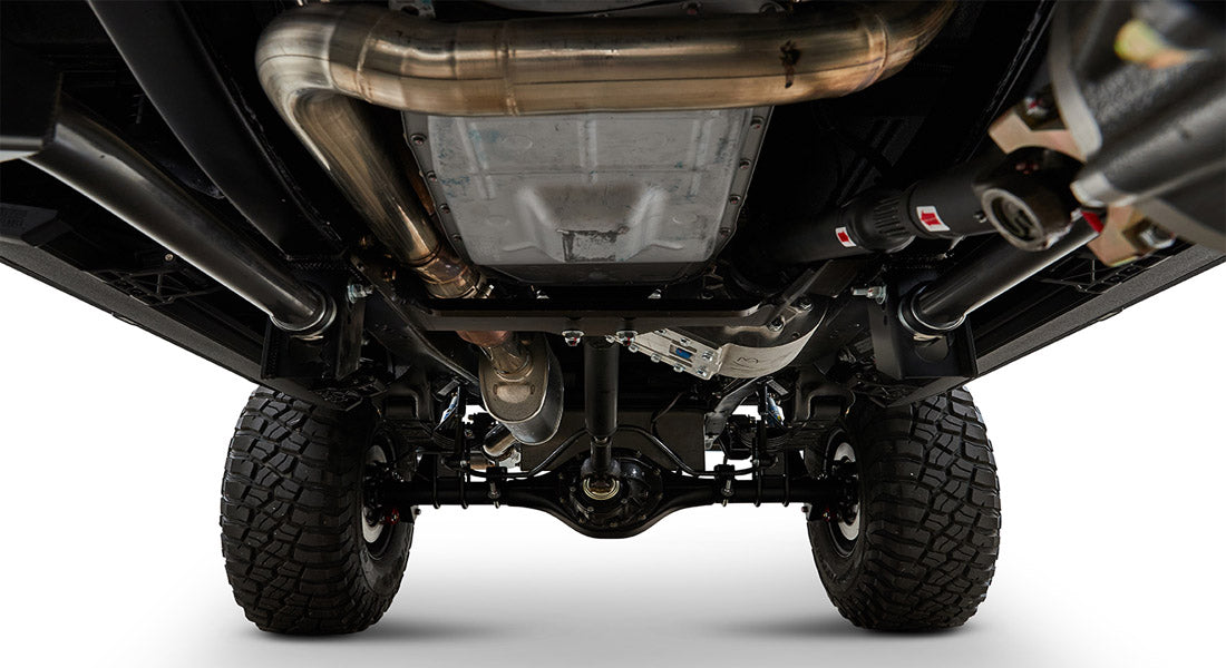 Undercarriage view showing exhaust system and off-road tires of a Classic Ford Bronco