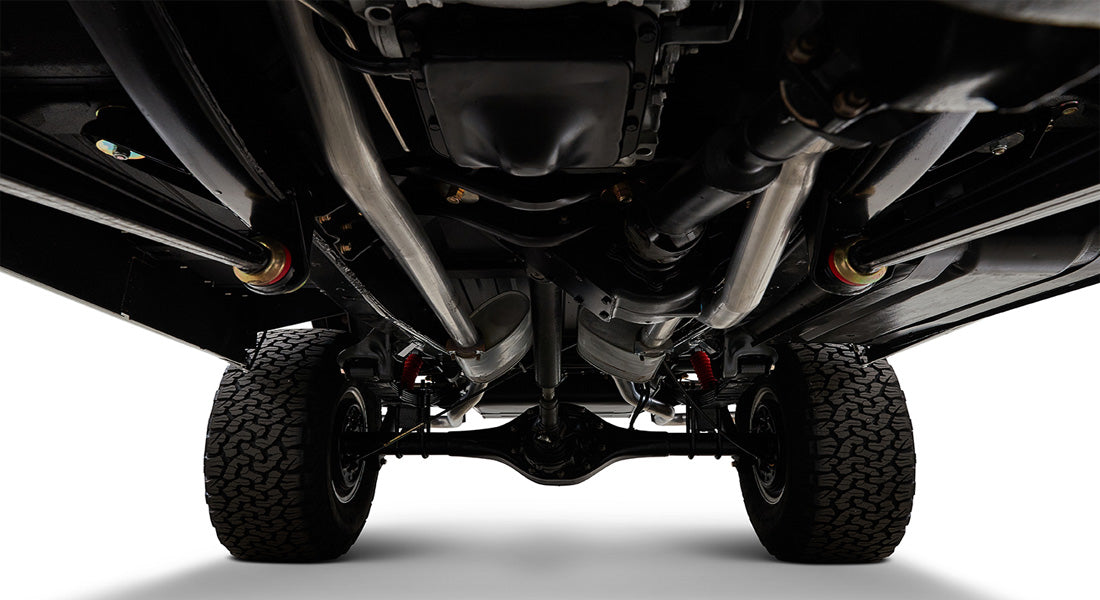 Undercarriage of Classic Ford Bronco showing suspension, exhaust system, and tires from below