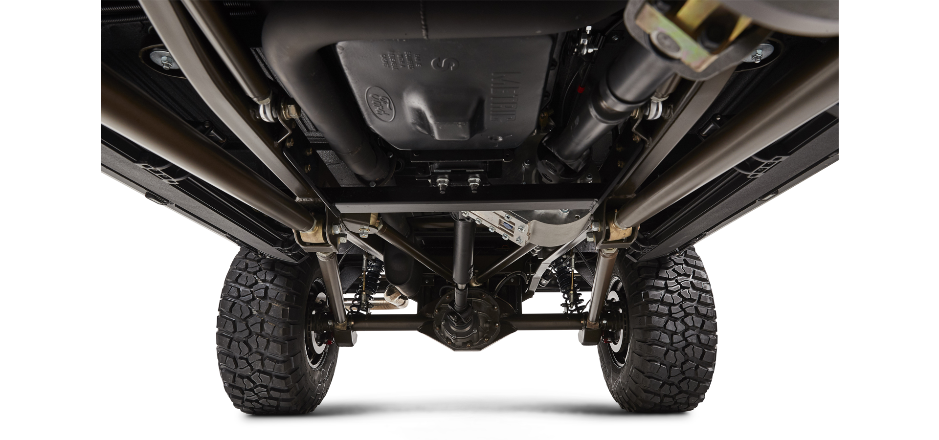 Undercarriage of Classic Ford Bronco showing suspension, axle, and wheels on white background