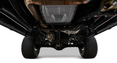 Undercarriage view of vehicle showing drive shaft, exhaust system, differential, and tires
