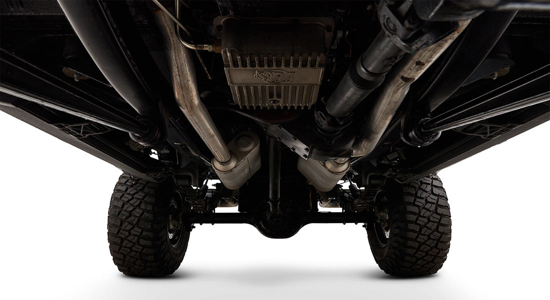 Undercarriage of Classic Ford Bronco showing axles, exhaust, and tires from below