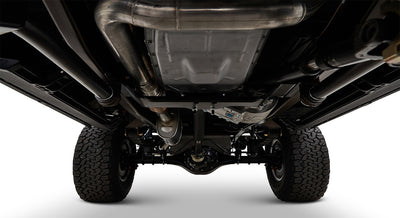 Undercarriage view of a Classic Ford Bronco showing suspension, exhaust, and tires from ground level