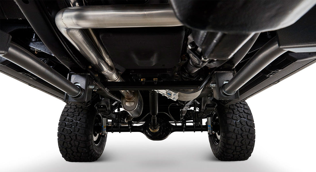 Undercarriage of a Classic Ford Bronco showing rear tires, axle, exhaust, and suspension components