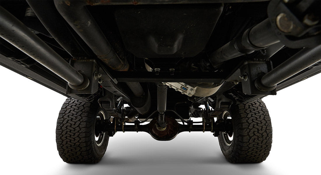Undercarriage view of a Classic Ford Bronco showing rear axle, suspension components, and tires.