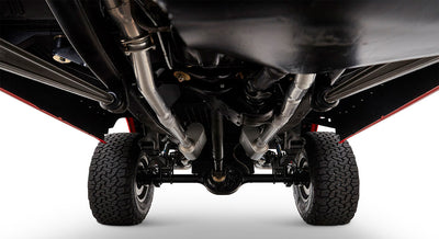 Undercarriage view showing exhaust system, suspension, and tires on black chassis