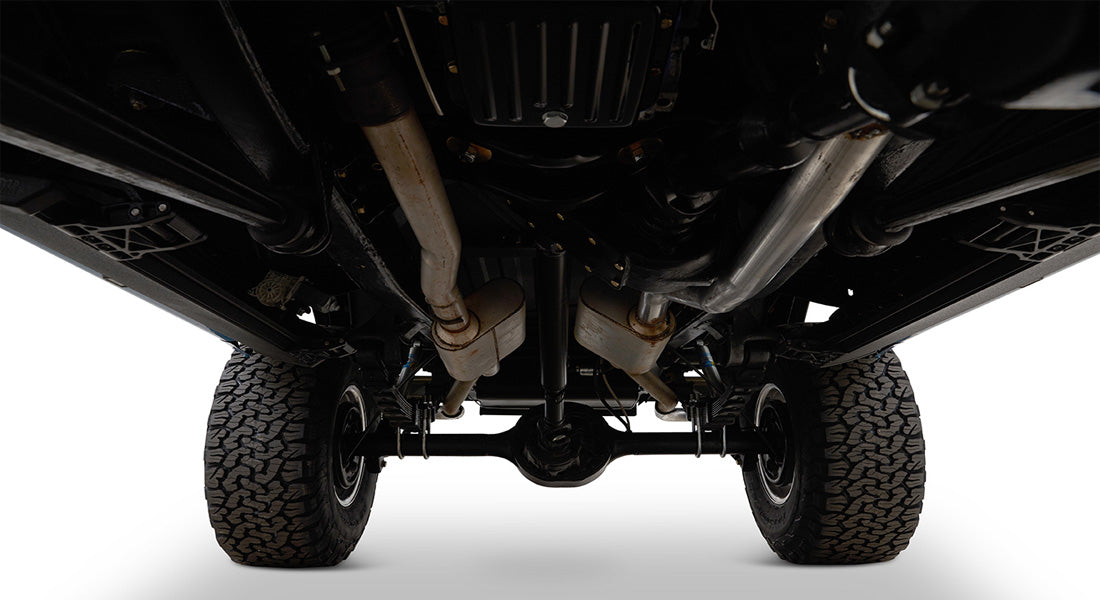 Undercarriage view of Classic Ford Bronco showing exhaust pipes, rear differential, and suspension.
