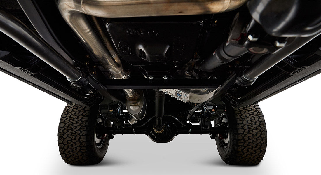 View of Classic Ford Bronco undercarriage showing exhaust pipes, driveshaft, and suspension
