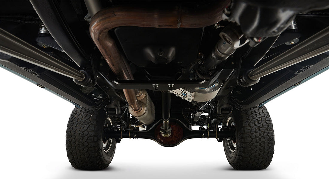 Undercarriage view showing suspension, exhaust, and tires of a Classic Ford Bronco