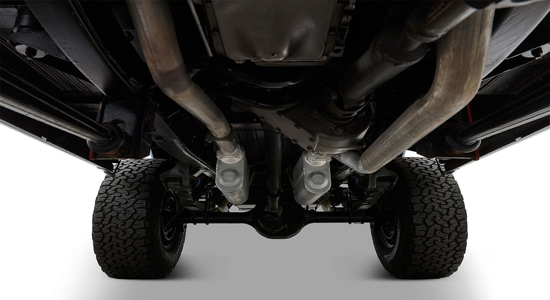 Clean undercarriage of a Classic Ford Bronco showing dual exhausts and suspension system