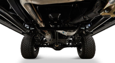 Undercarriage view showing exhaust pipes, suspension, and tires of a Classic Ford Bronco