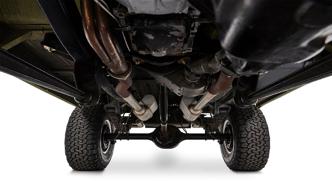 Detailed undercarriage view of Classic Ford Bronco with dual exhaust pipes and rear end components.