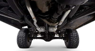 View of Classic Ford Bronco undercarriage showing suspension, axles, exhaust pipes, and tires