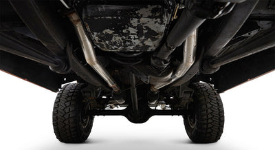 Undercarriage view showing metal frame, axle, tires, and exhaust pipes of Classic Ford Bronco