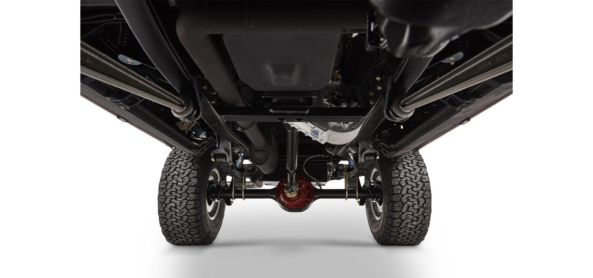 Undercarriage of Classic Ford Bronco showing suspension, drive shaft, and rear axle with tires