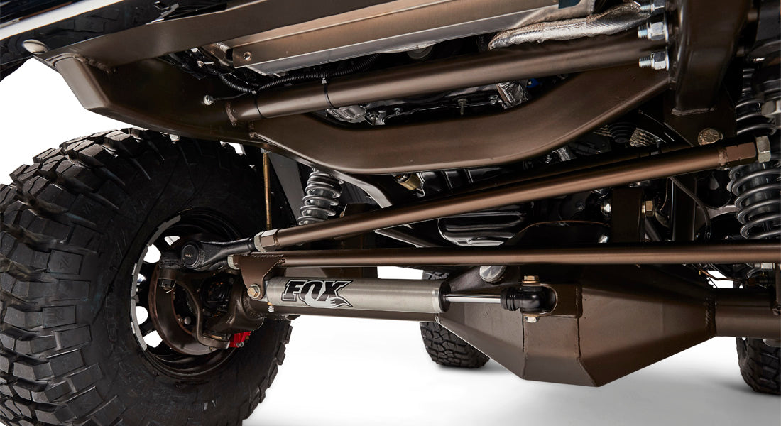 Close-up detail of suspension and shock absorber labeled FOX beneath Classic Ford Bronco