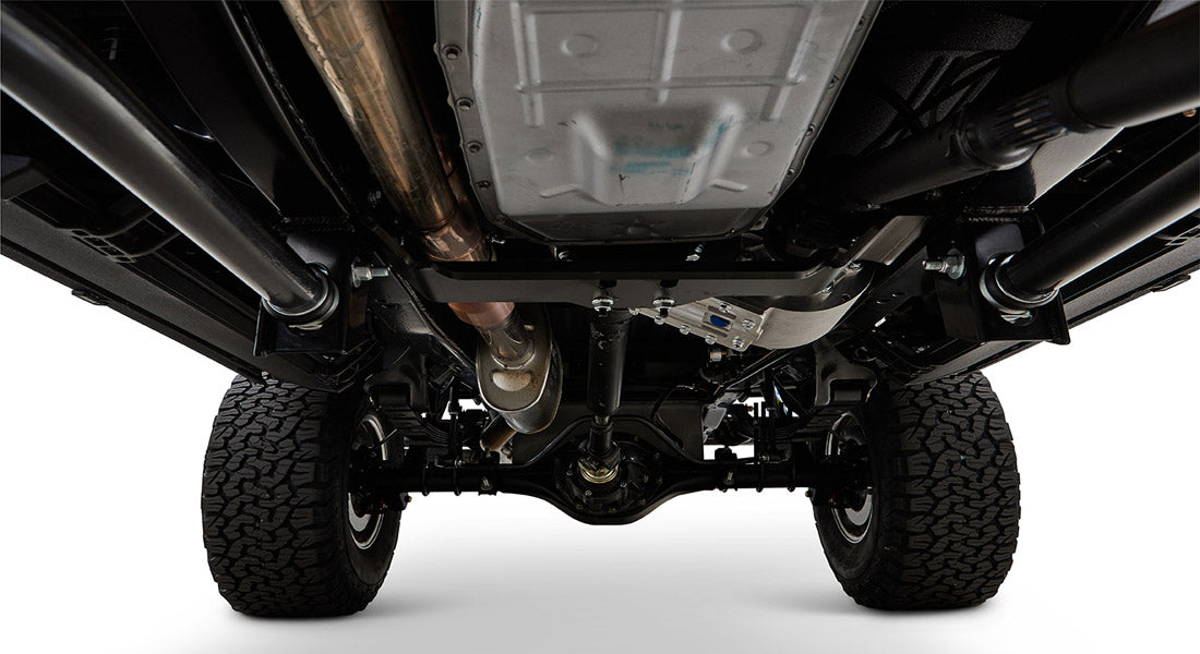 Undercarriage view showing tires, axle, drive shaft, and exhaust system of Classic Ford Bronco.