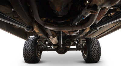 Undercarriage of a Classic Ford Bronco showing suspension, exhaust, and tires from below