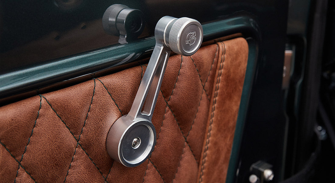 Manual window crank and quilted brown leather door panel inside Classic Ford Bronco