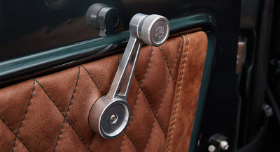 Manual window crank and quilted brown leather door panel inside Classic Ford Bronco